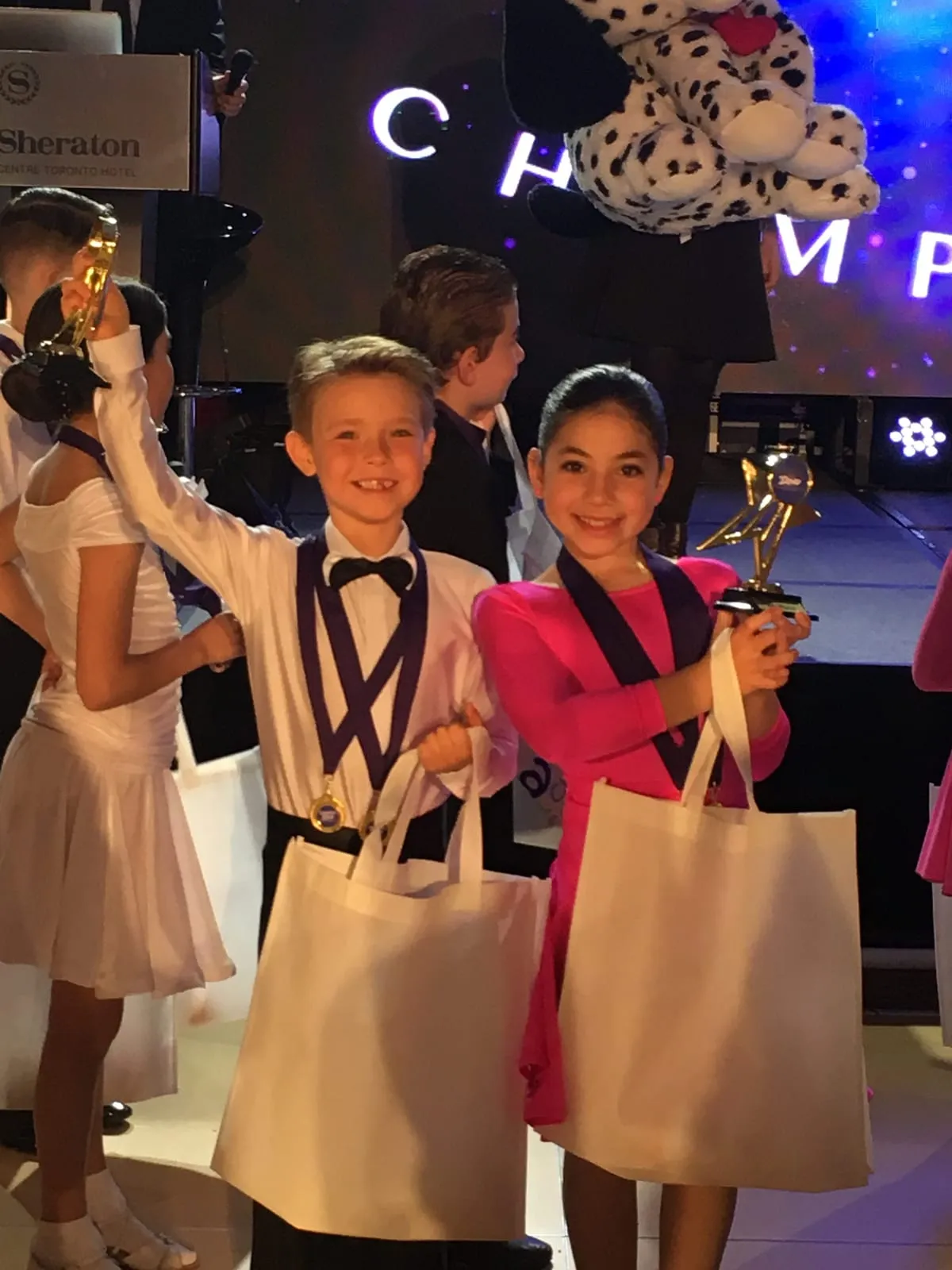 Two young dancers holding their trophies at a championship