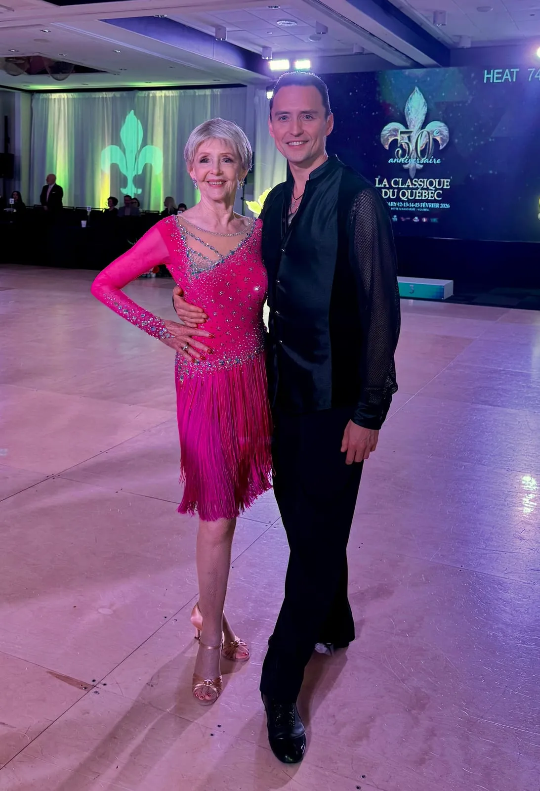 Marion Foers in a pink fringed Latin dress with her teacher Dmitry Ilyushenov on the competition floor