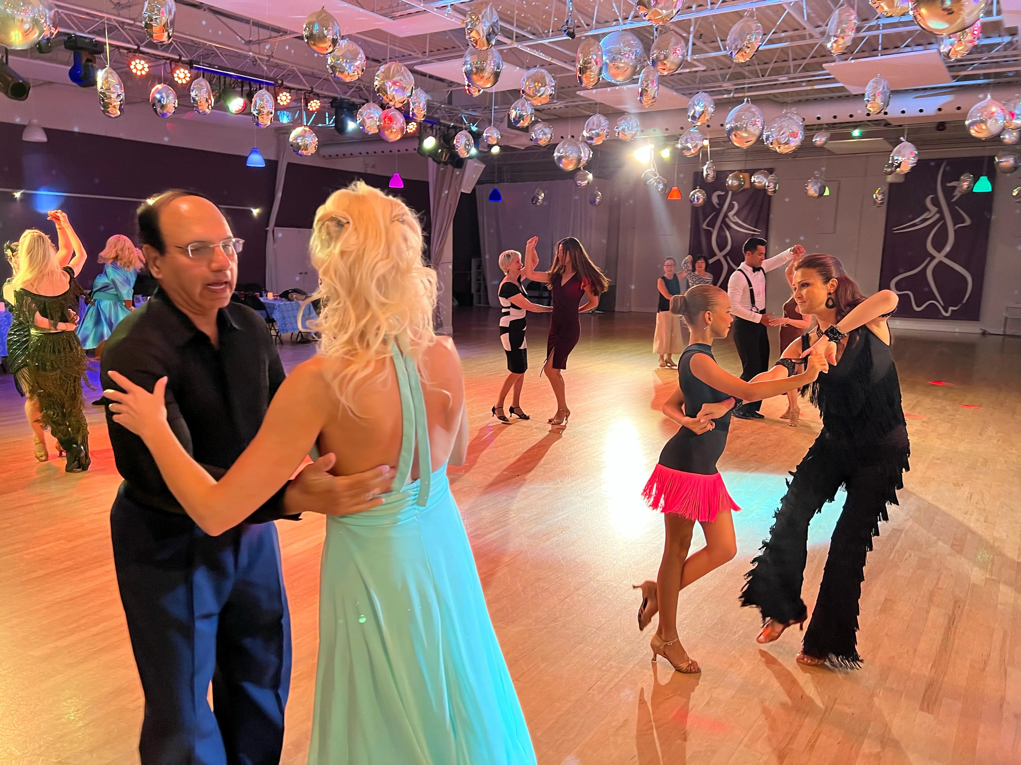 Couples dancing socially on a crowded dance floor