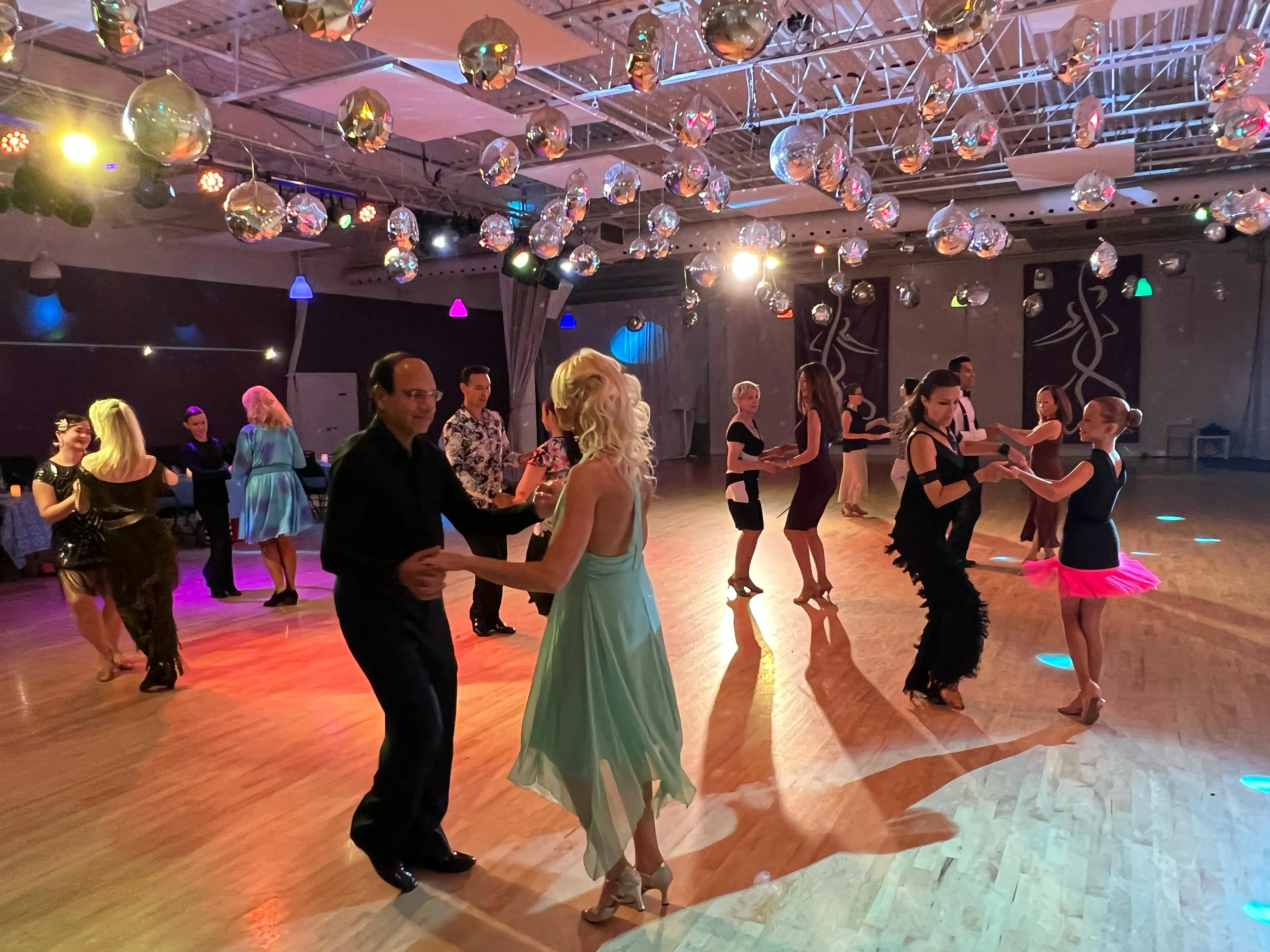 Several couples dancing at an evening social event