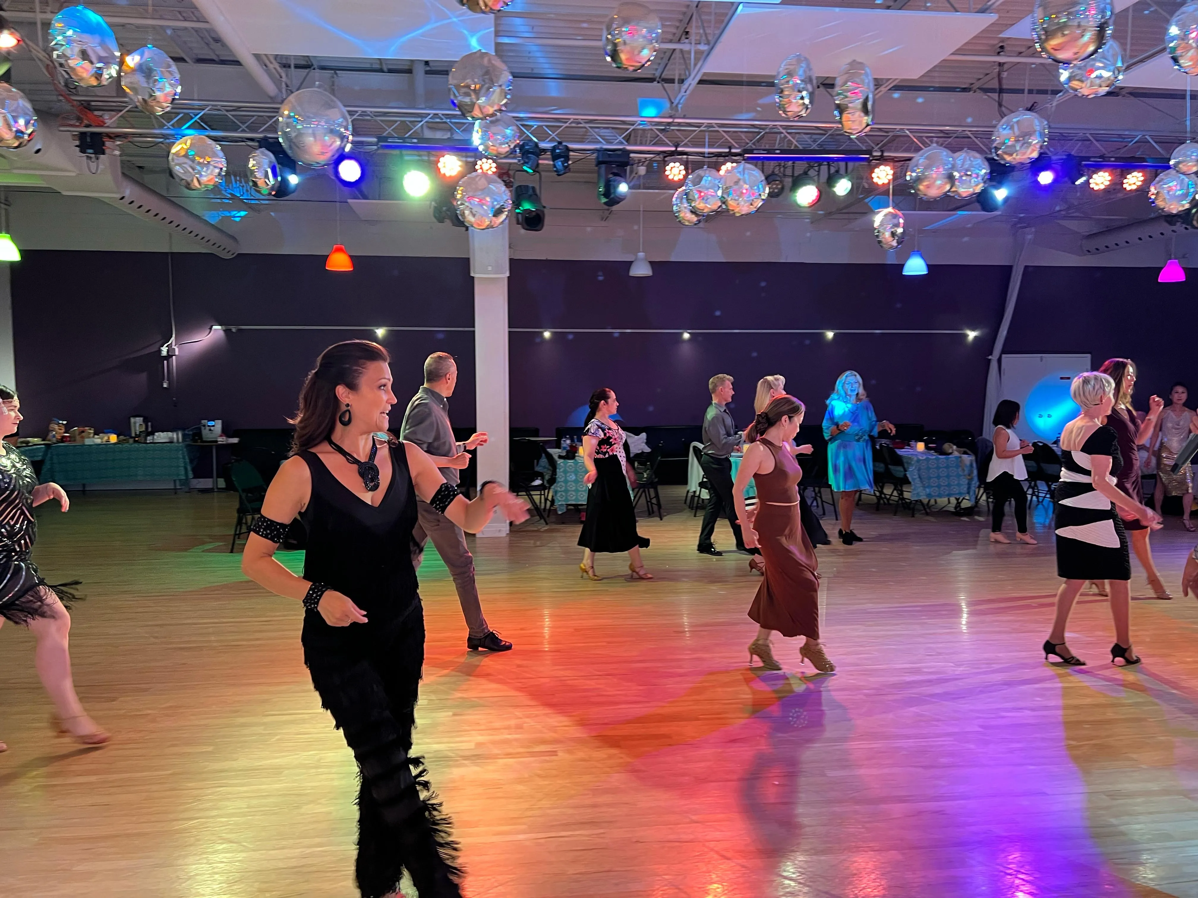 A student dancing at a social event with friends nearby