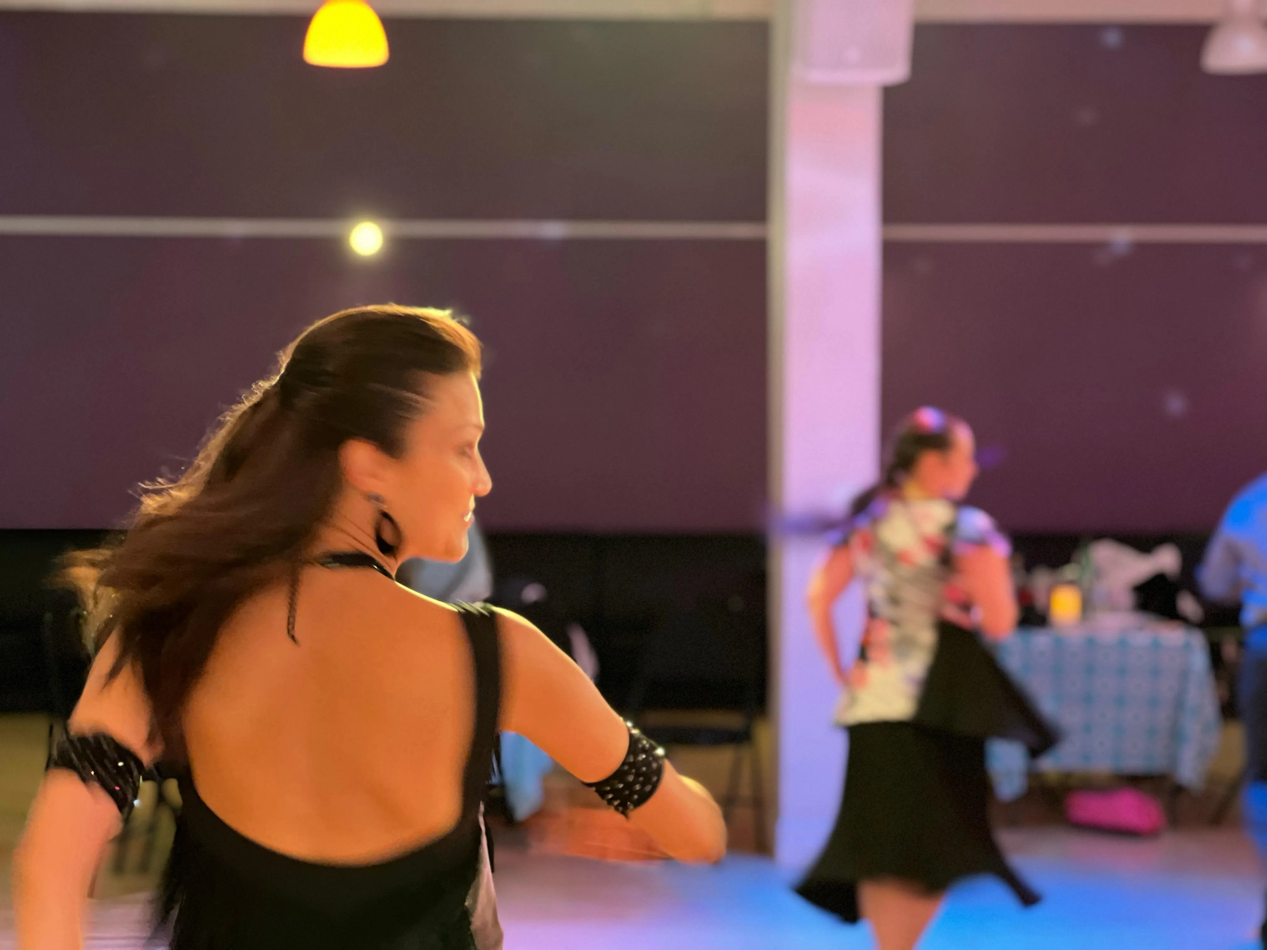 A student mid-turn on the dance floor at a social event