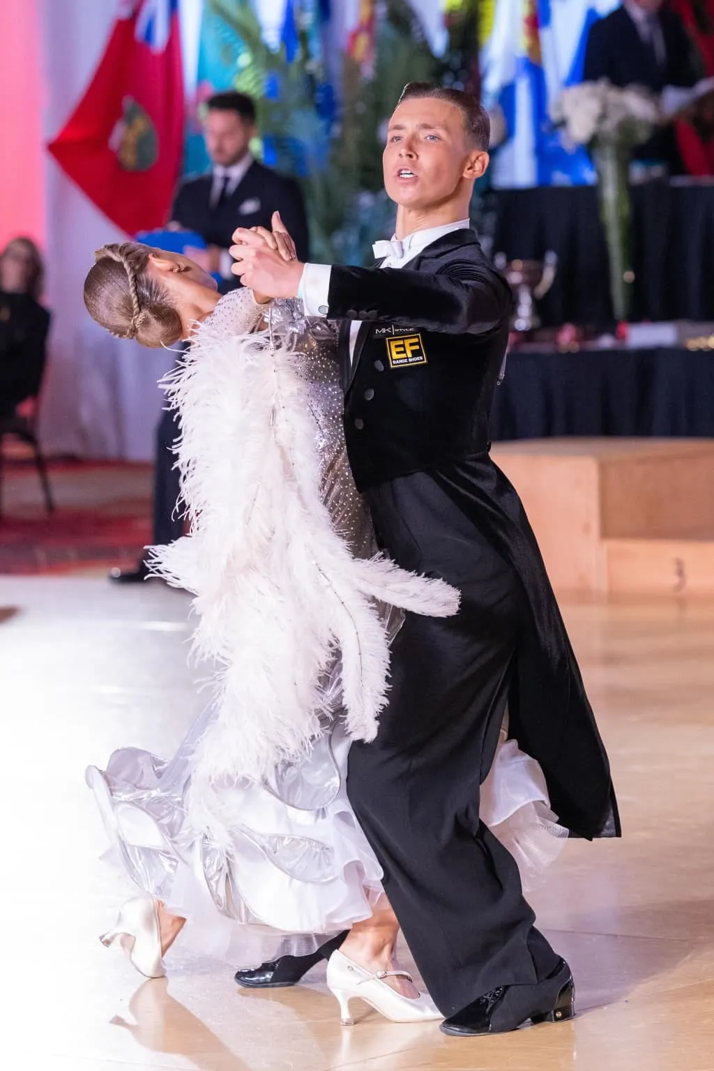 Sophia Baydala and Andrey Ilyushenov mid-routine in ballroom competition dress
